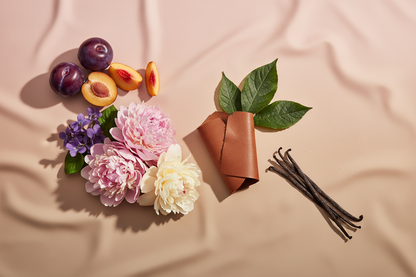 generate a modern product image displaying the following individual notes, with a pink/beige/taupe background: plum, peach, violet, peony, leather, patchouli, vanilla, dust