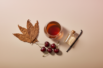 generate an image showing individual notes for a modern product image, in a pink/beige/taupe background, including: cognac, tobacco, cherry, vanilla extract