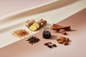 generate an image showing individual notes for a modern product image, in a pink/beige/taupe background, including: sugar, ginger, molasses, cinnamon, almond, cloves